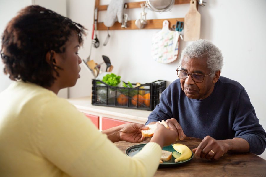 Carer helping an older man with his morning routine